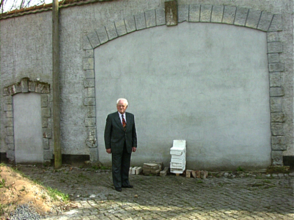 Friedrich Klingenberg vor den von ihm als Häftling des Männerlagers gemauerten Bögen in der Ravensbrücker Lagermauer (Dreharbeiten 1995)