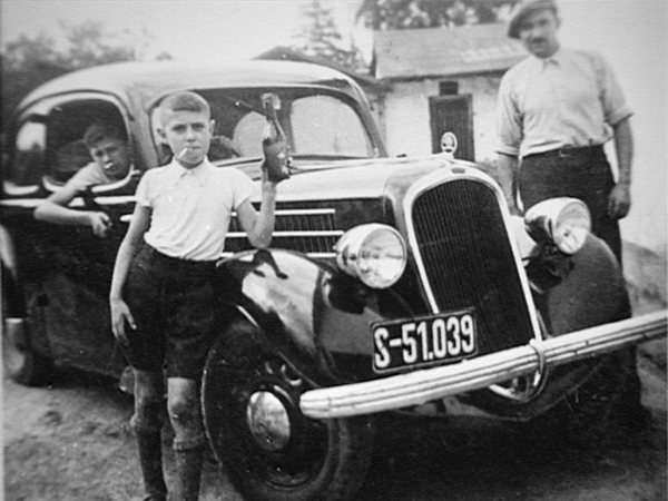 Walter Morgenbesser mit Zigarette vor einem Auto der Firma Pollak. (Quelle: Privat W. Morgenbesser)